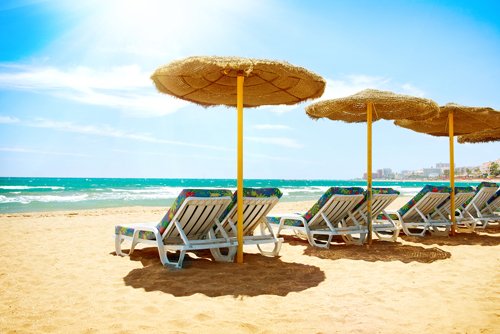Deck chairs on a sunny beach on the Costa del Sol, Spain