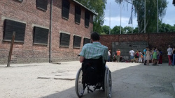 A visitor in a wheelchair in Auschwitz-Birkenau, Poland